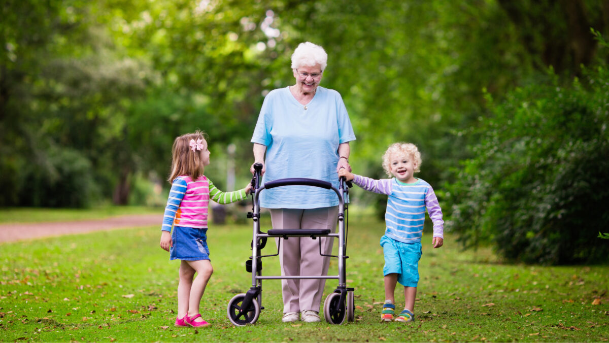Get a free mobility aid. Senior woman using rollator, walking with her grandchildren.