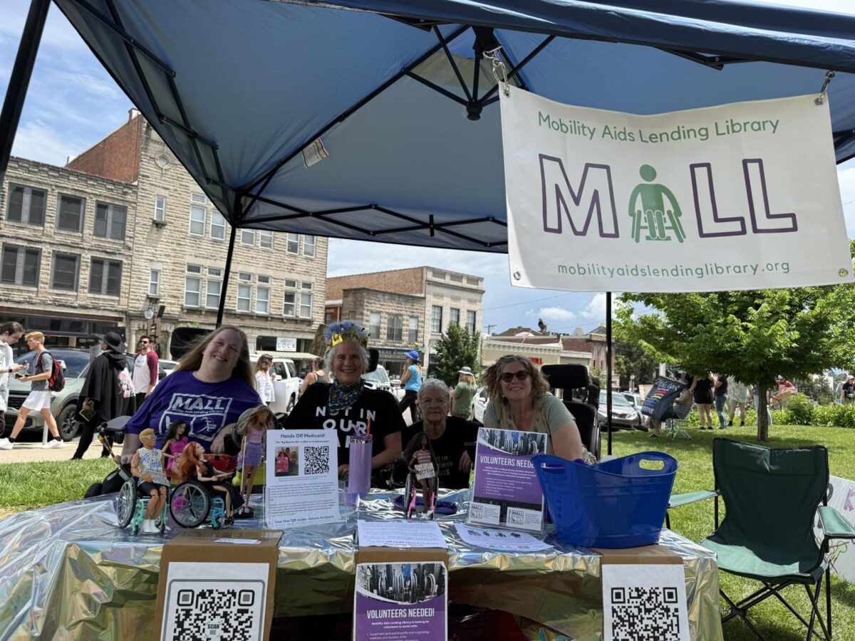 MALL staff sitting in their booth at an event