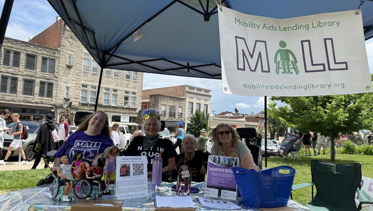 MALL staff sitting in their booth at an event